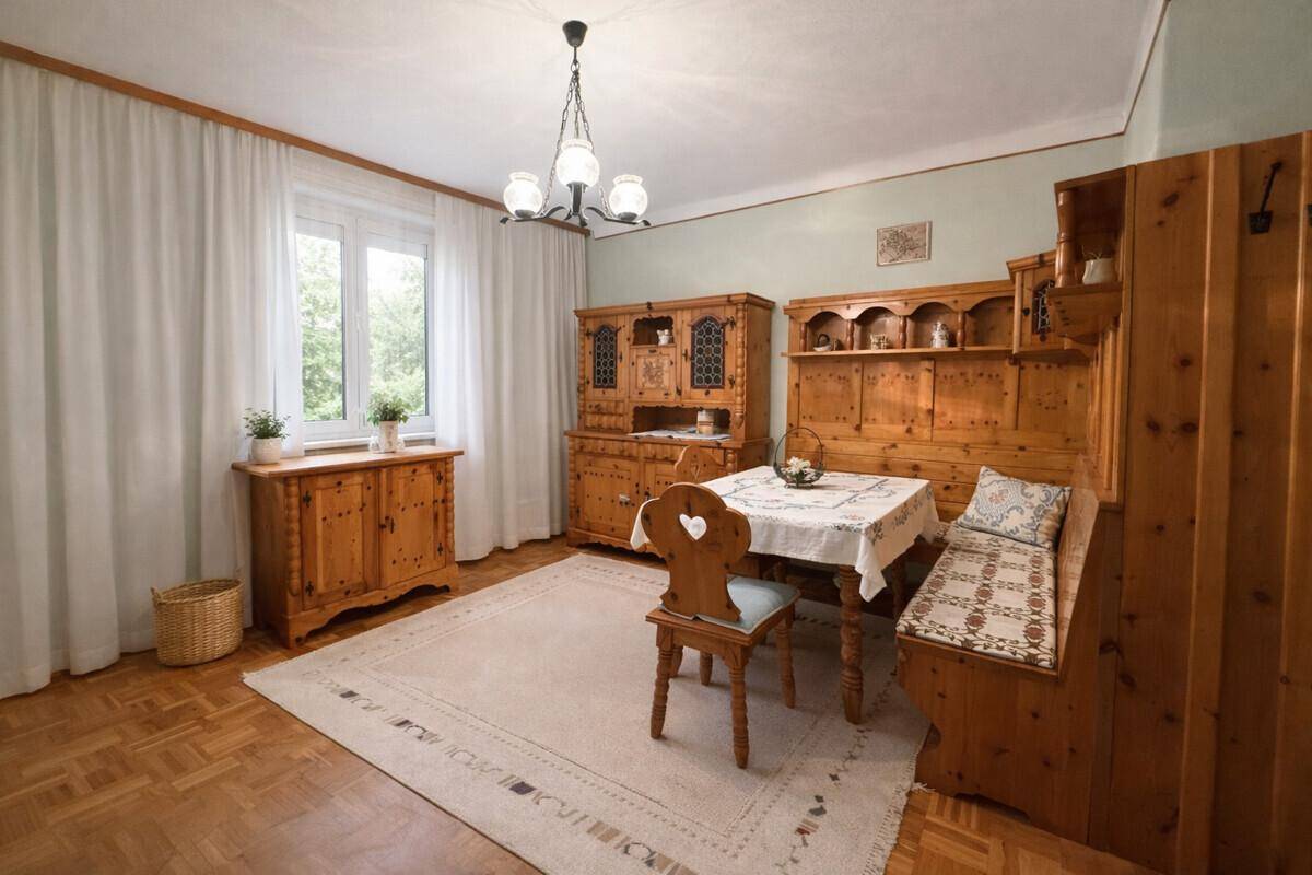 Traditioneller Essbereich mit rustikalen Holzmöbeln, Eckbank und Parkettboden in warmen Tönen.