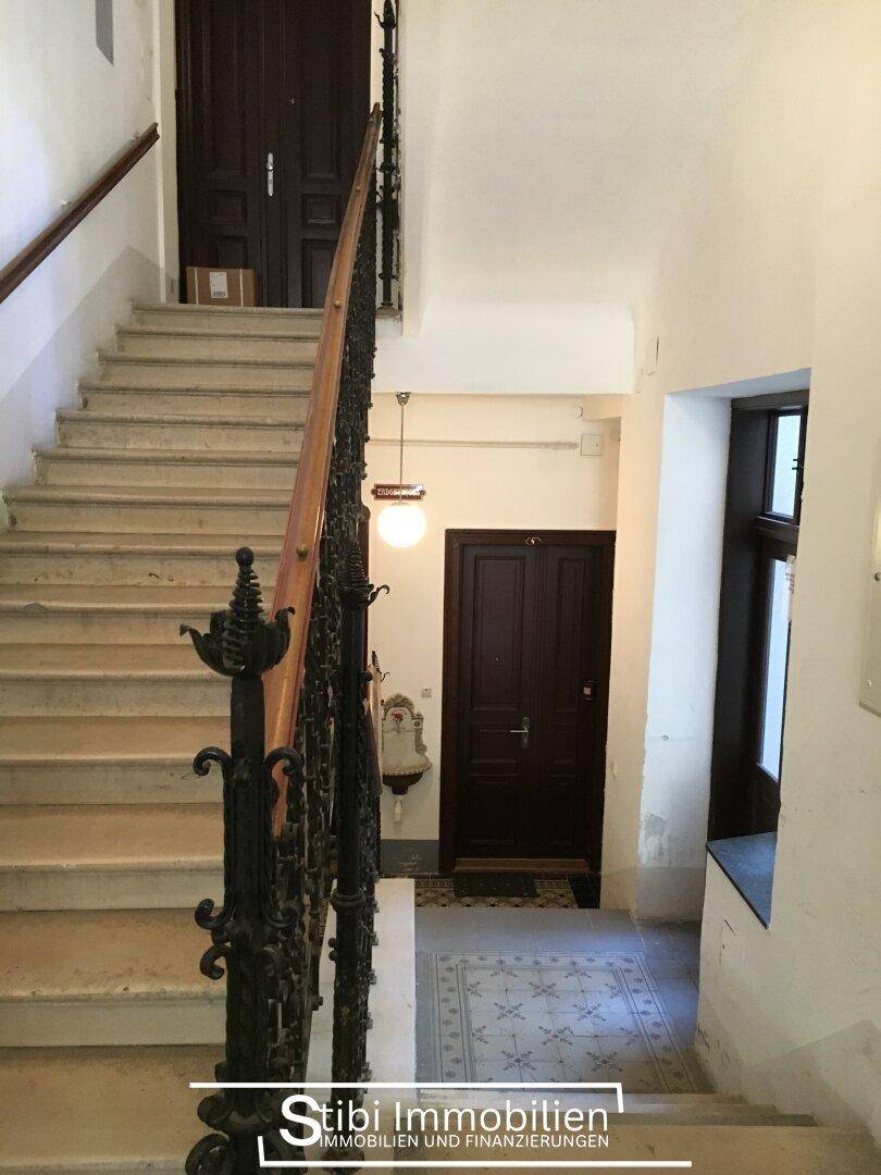 Historisches Treppenhaus mit Marmorstufen und kunstvollem schmiedeeisernem Geländer in einem Altbau.