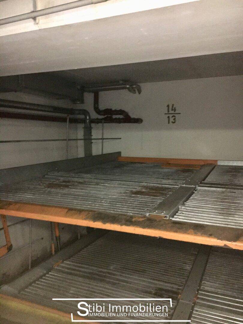 Doppelparker-System in der Tiefgarage für effiziente Raumnutzung mit sichtbaren Leitungen.