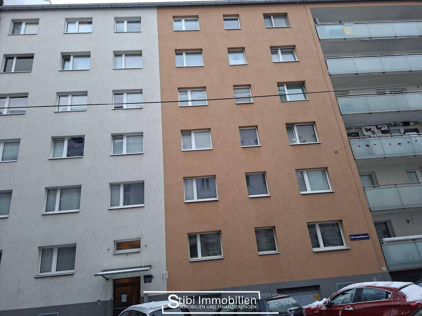 Fassade eines Mehrfamilienhauses mit vielen Fenstern und Balkonen.