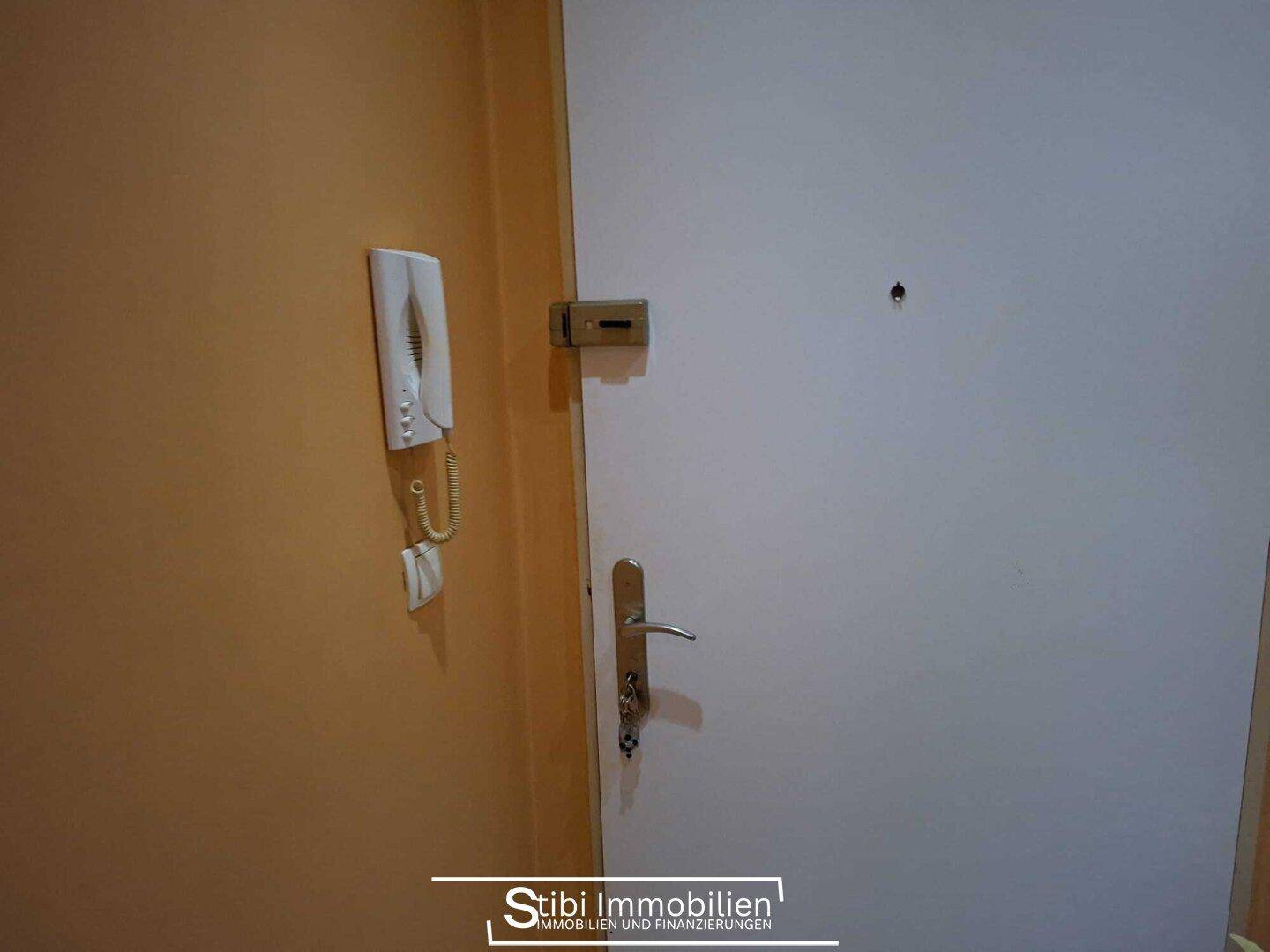 Eingangsbereich mit Gegensprechanlage und Sicherheitsschloss an der Wohnungstür.