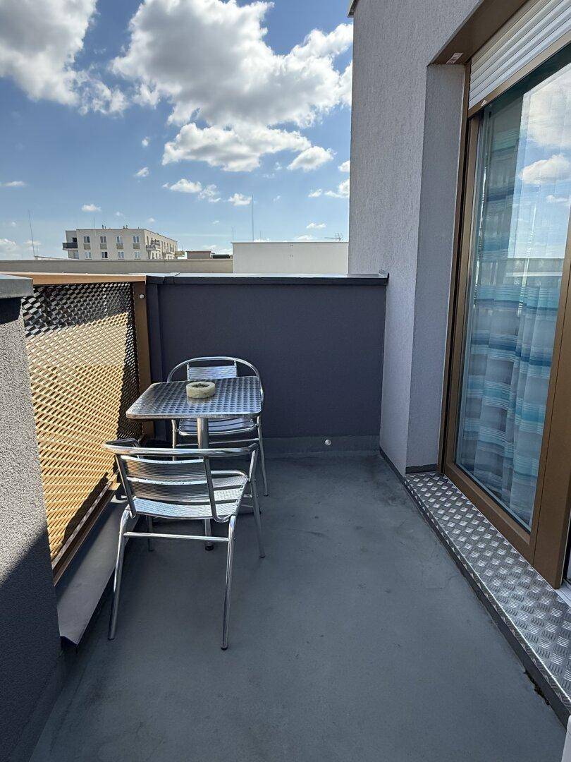 Kleiner Balkon mit Metallmöbeln, ideal für entspannte Stunden im Freien.
