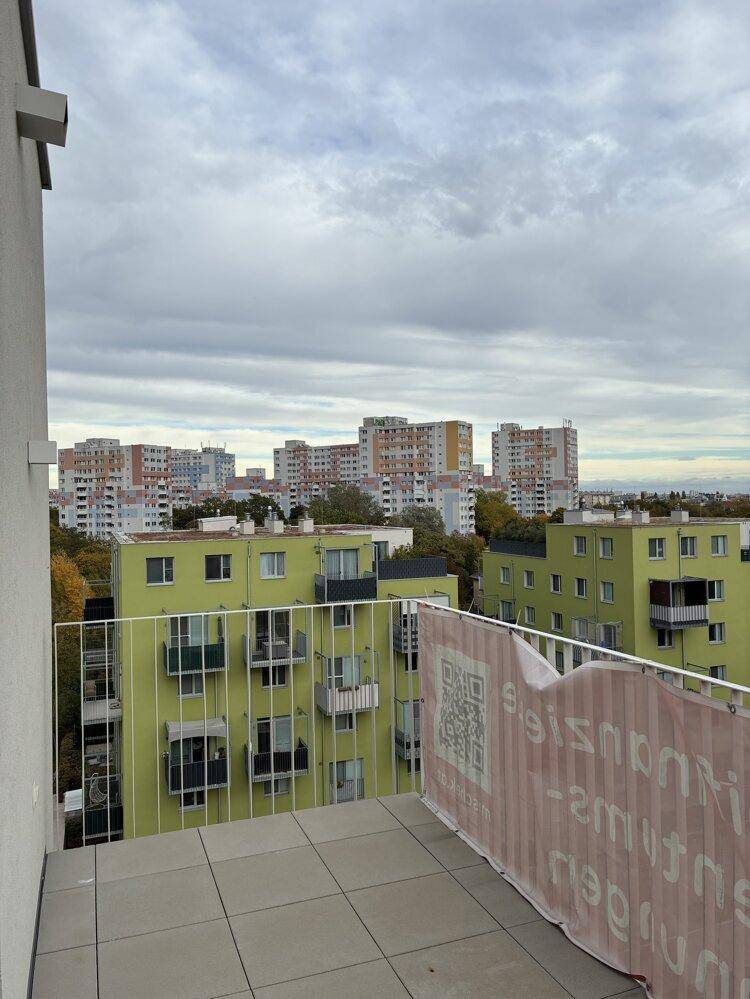 Großer Balkon mit Fliesenboden und Panoramablick auf die umliegenden Gebäude.