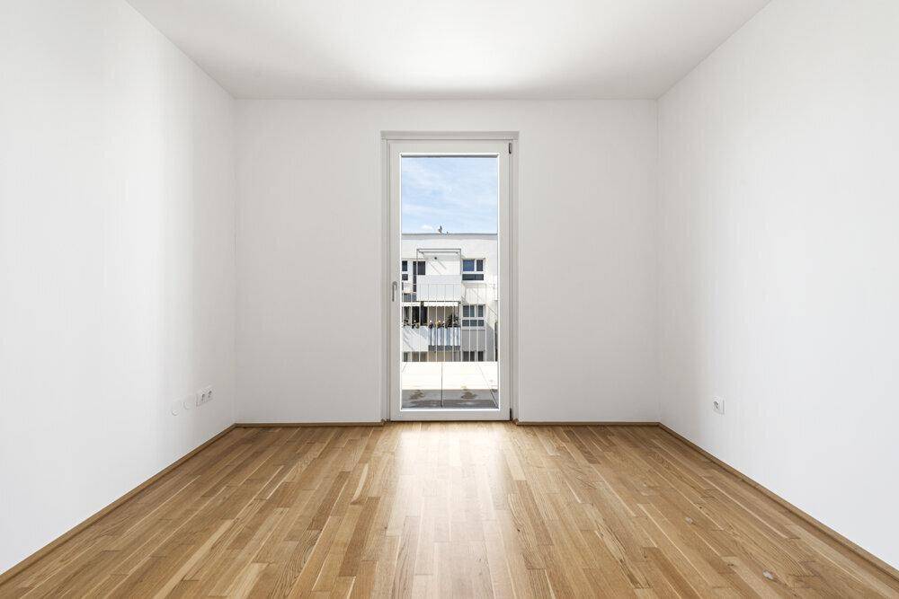 Helles Zimmer mit Parkettboden und französischem Balkon, bietet viel Tageslicht.