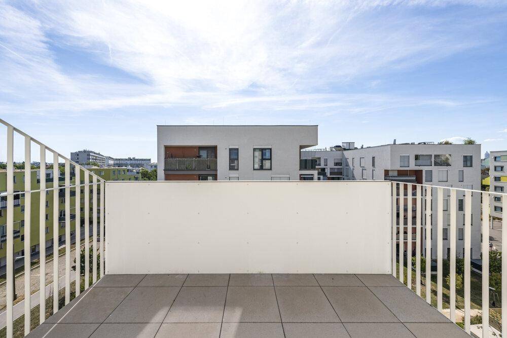 Geräumiger Balkon mit Fliesenboden und weitem Blick über die Stadtlandschaft.