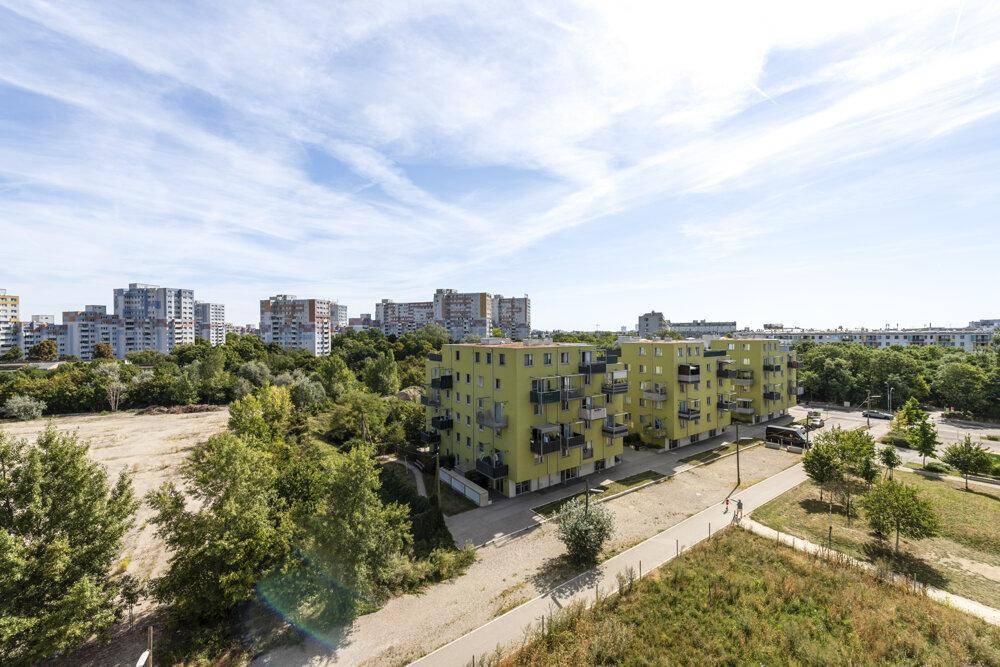Panoramablick über eine städtische Landschaft mit Wohngebäuden und viel Grün.