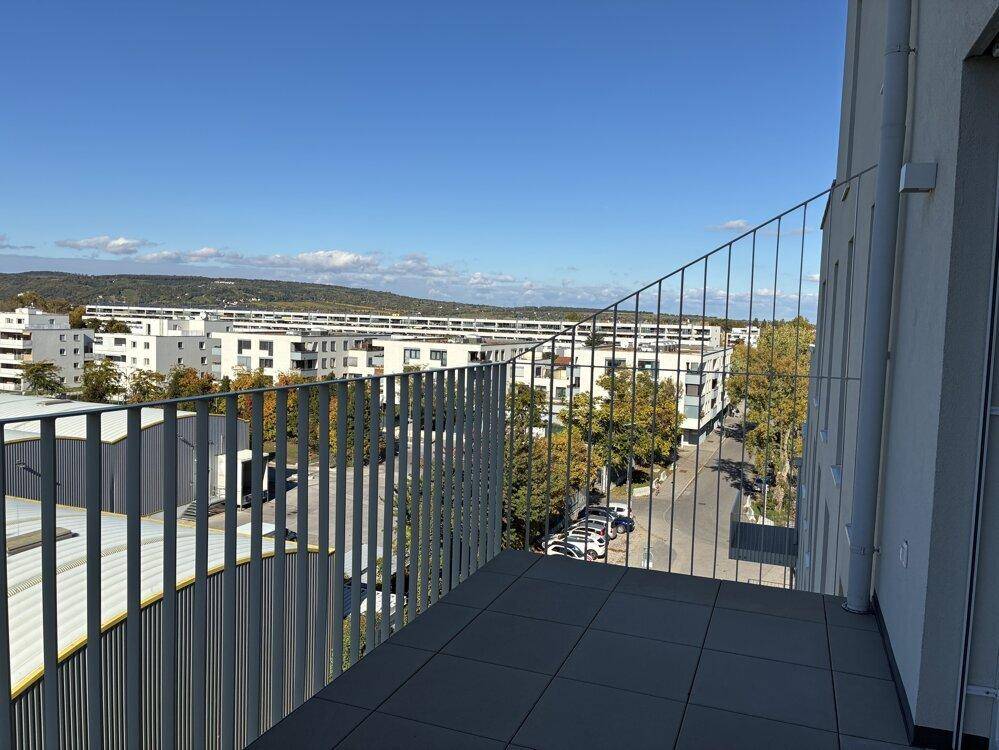 Balkon mit Fliesenboden und weitem Blick über die Stadt und die umliegende Landschaft.