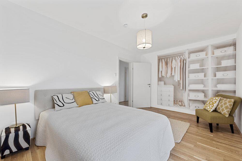 Geräumiges Schlafzimmer mit Doppelbett, Holzboden und praktischem Einbauschrank für Kleidung.