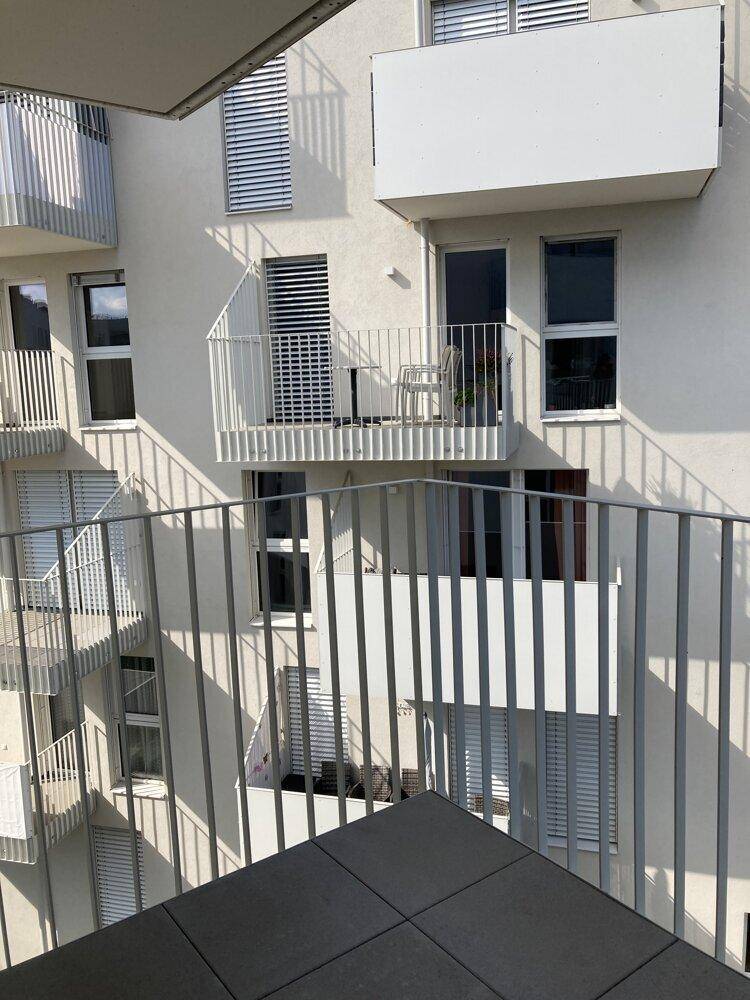 Blick von einem Balkon auf andere Balkone des modernen Wohngebäudes mit Metallgeländern.