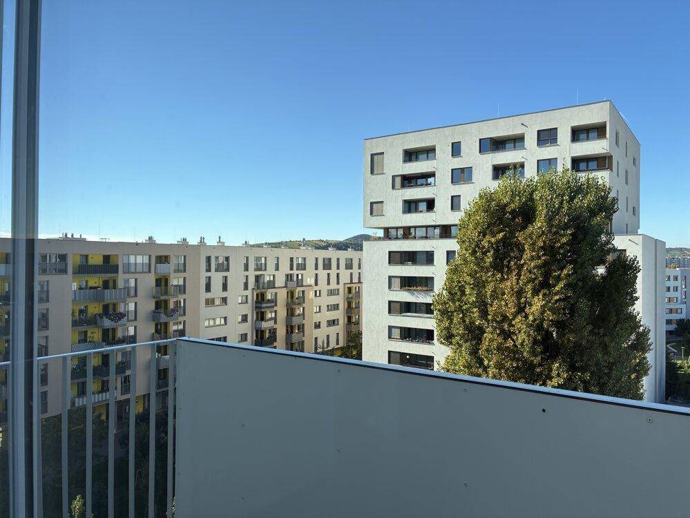 Ausblick vom Balkon auf weitere moderne Wohngebäude und die grüne Umgebung.