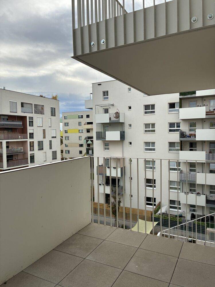 Balkon mit Metallgeländer und Aussicht auf die umliegende Wohnsiedlung.