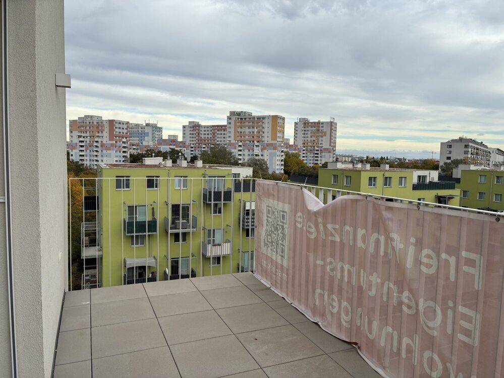 Geräumiger Balkon mit Fliesenboden und weitem Blick über die Stadt.