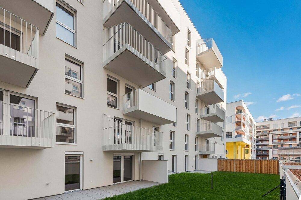 Moderne Wohnanlage mit Terrassen und Balkonen im Erdgeschoss und den oberen Etagen.