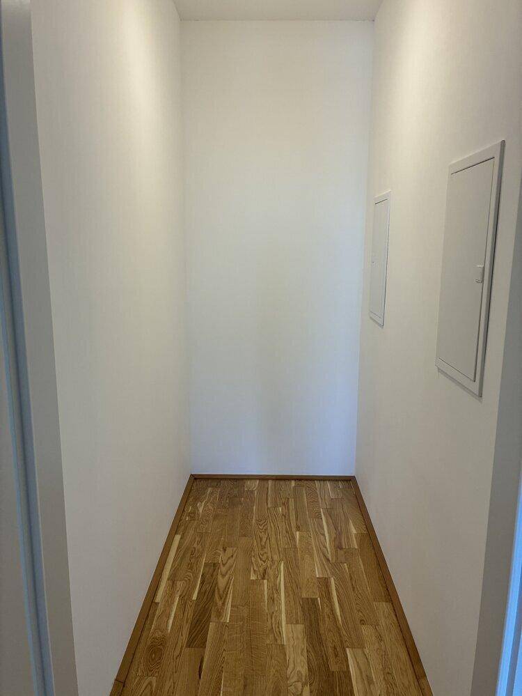 Praktischer Abstellraum mit Holzboden und weißen Wänden, ideal für zusätzlichen Stauraum.