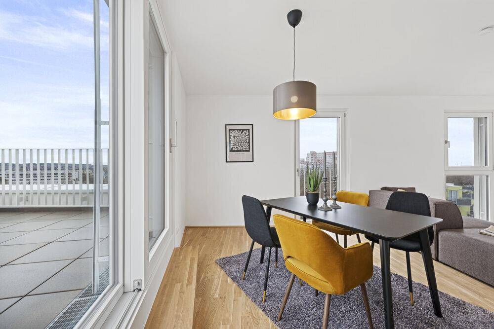 Essbereich mit direktem Zugang zur Dachterrasse durch große Schiebetüren, bietet viel Tageslicht.
