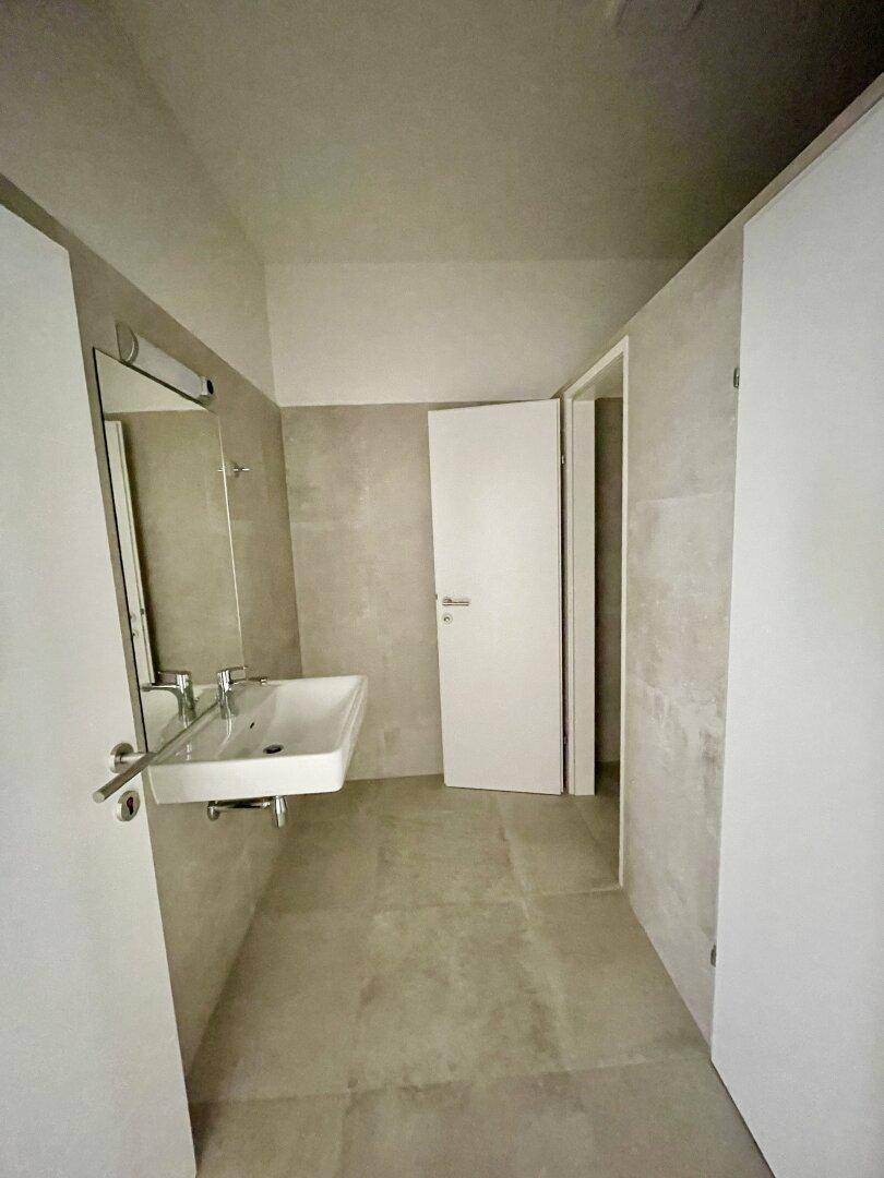 Helles Badezimmer mit modernem Waschbecken und Fliesen, bereit für die Endmontage.
