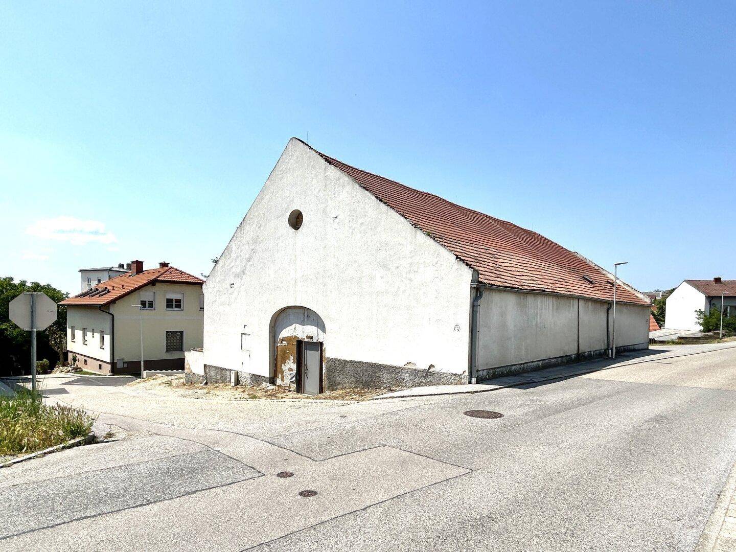 Ansicht des alten Gebäudes mit markantem Giebel und Ziegeldach an einer Straßenecke.