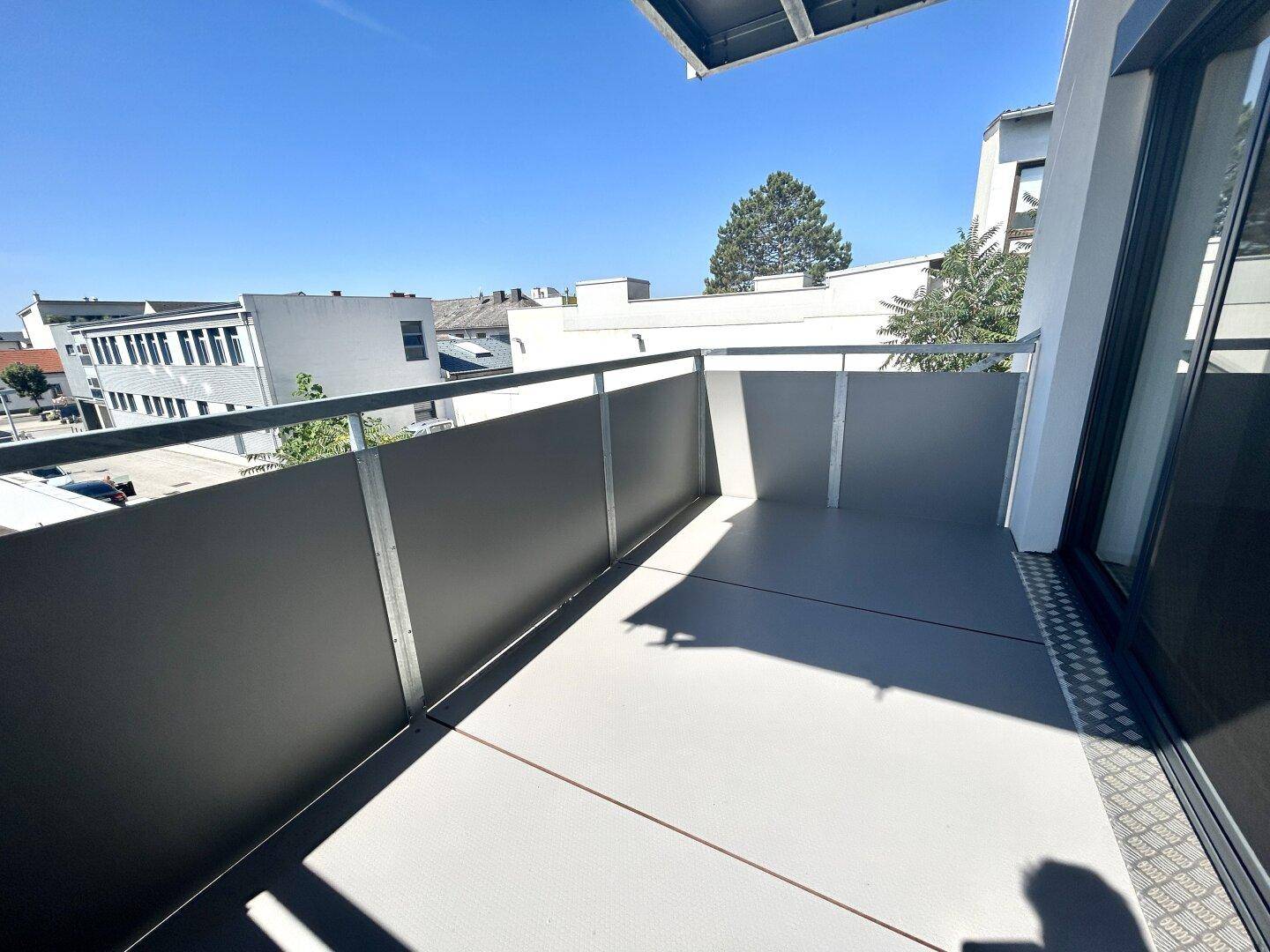 Balkon mit moderner Brüstung und Blick auf die städtische Umgebung.