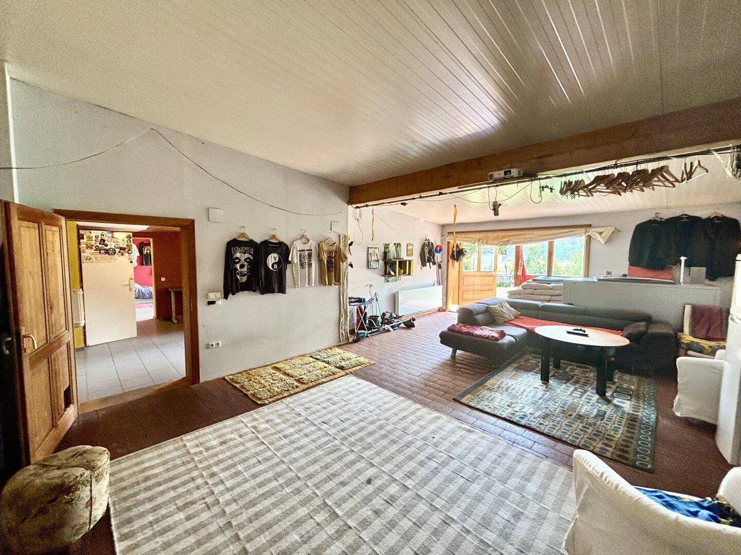 Geräumiges Wohnzimmer mit Terrakotta-Fliesenboden, Sofa und Zugang zum Außenbereich.