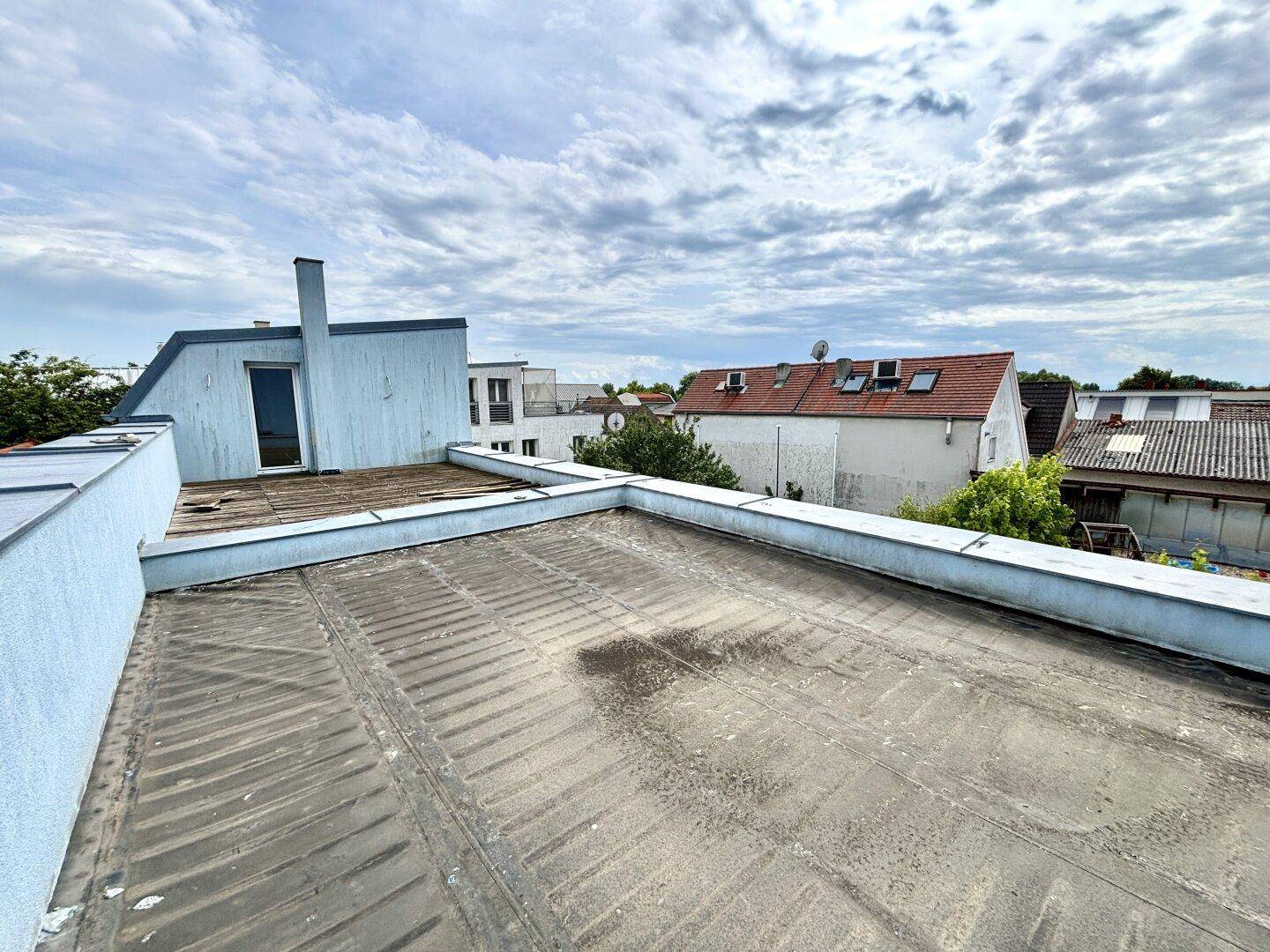 Flachdachbereich mit Zugangstür, der als zukünftige Dachterrasse genutzt werden könnte.
