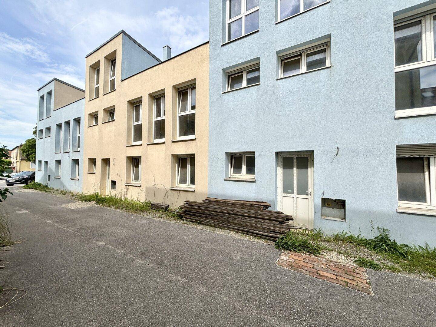 Reihe moderner Häuser mit farbigen Fassaden entlang einer ruhigen Straße.