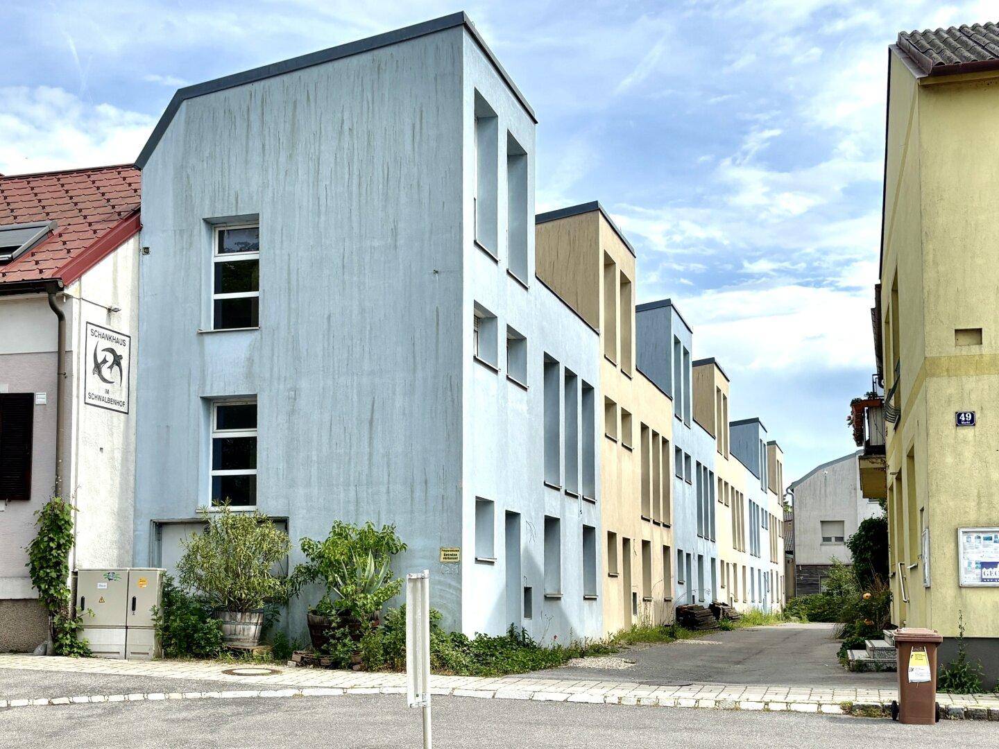 Ansicht der modernen Reihenhäuser mit unterschiedlichen Fassadenfarben und architektonischen Details.