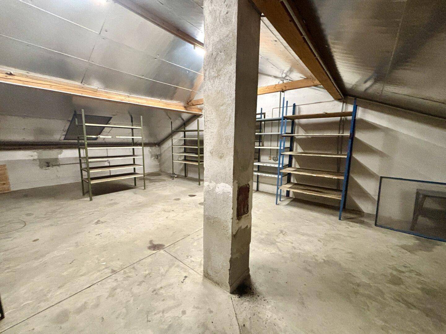 Dachboden als Lagerraum mit Regalen und sichtbaren Dachbalken, bereit zur Nutzung.