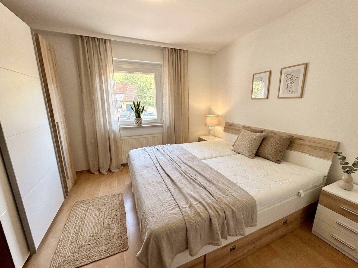 Gemütliches Schlafzimmer mit Doppelbett, hellem Holzboden und einem großen Kleiderschrank.