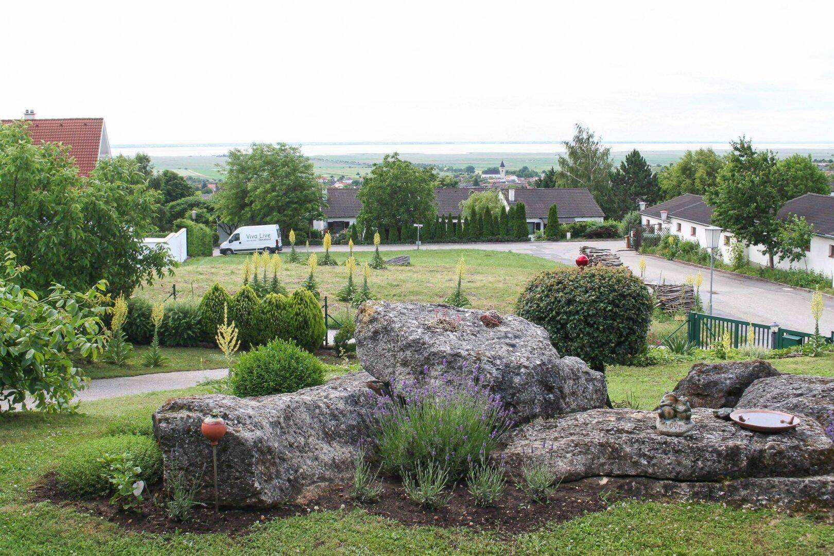 Gepflegter Garten mit großen Felsen, Lavendel und weitem Blick über die Landschaft.