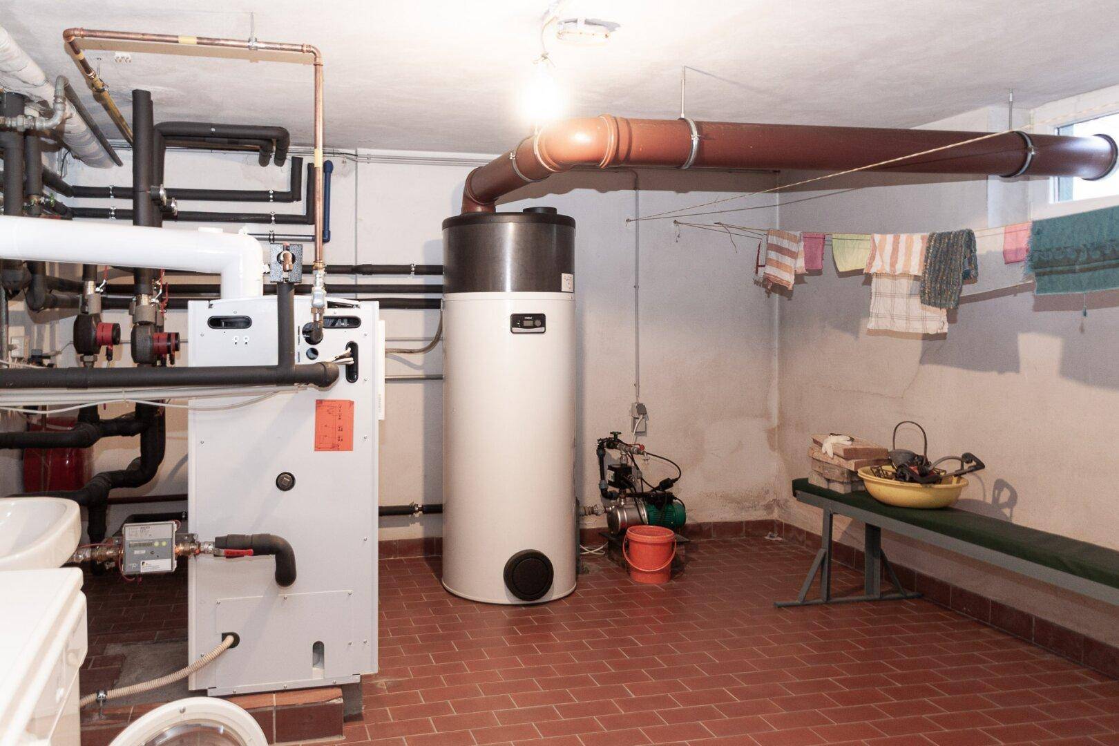 Heizungsraum im Keller mit moderner Anlage und Wäscheleine.