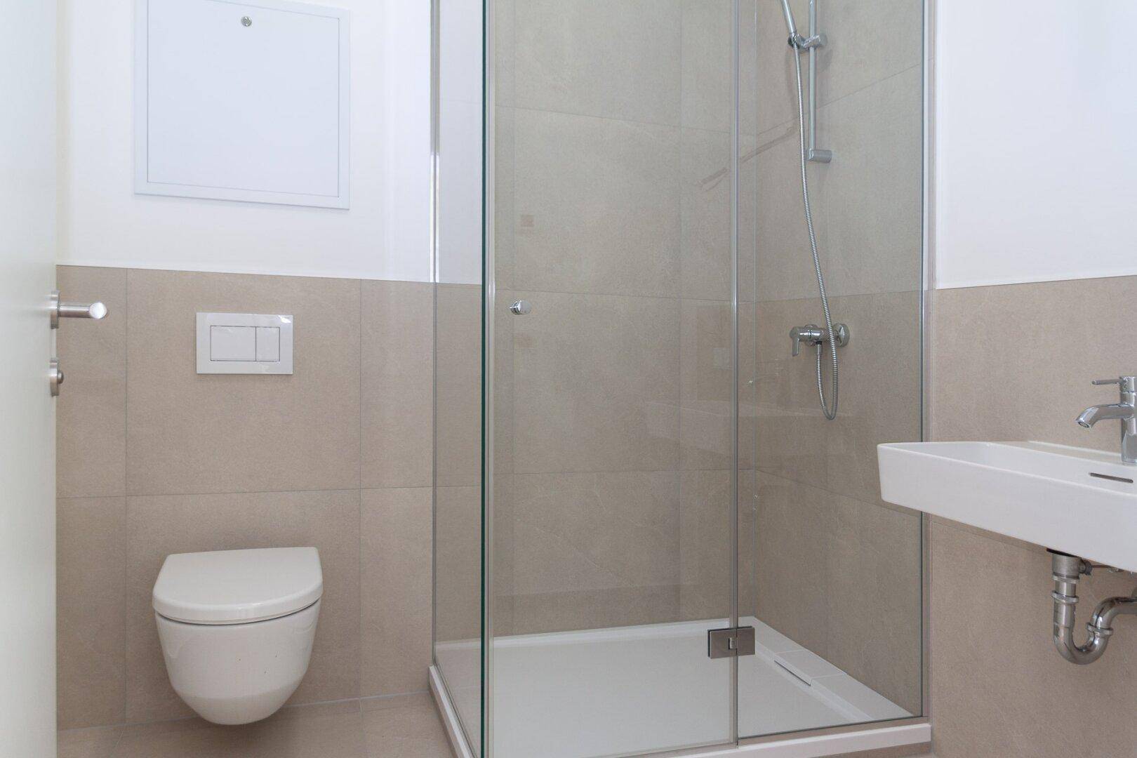 Modernes Badezimmer mit Duschkabine, Wand-WC und Einzelwaschbecken.