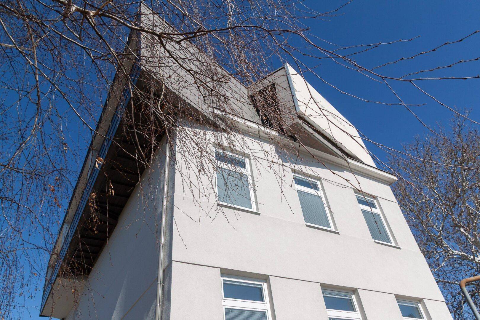Moderne Architektur des Gebäudes mit markantem Dach und hellen Fassaden.