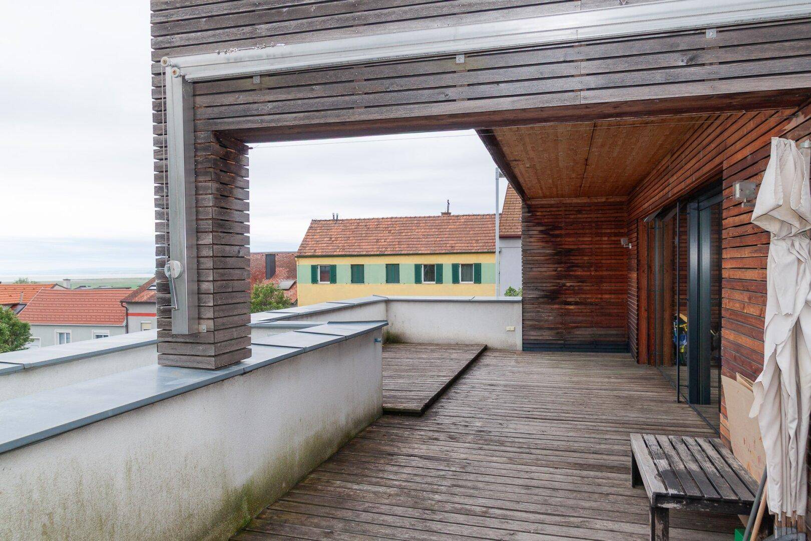 Terrasse mit weitem Blick über Dächer, Häuser und einen See in der Ferne.