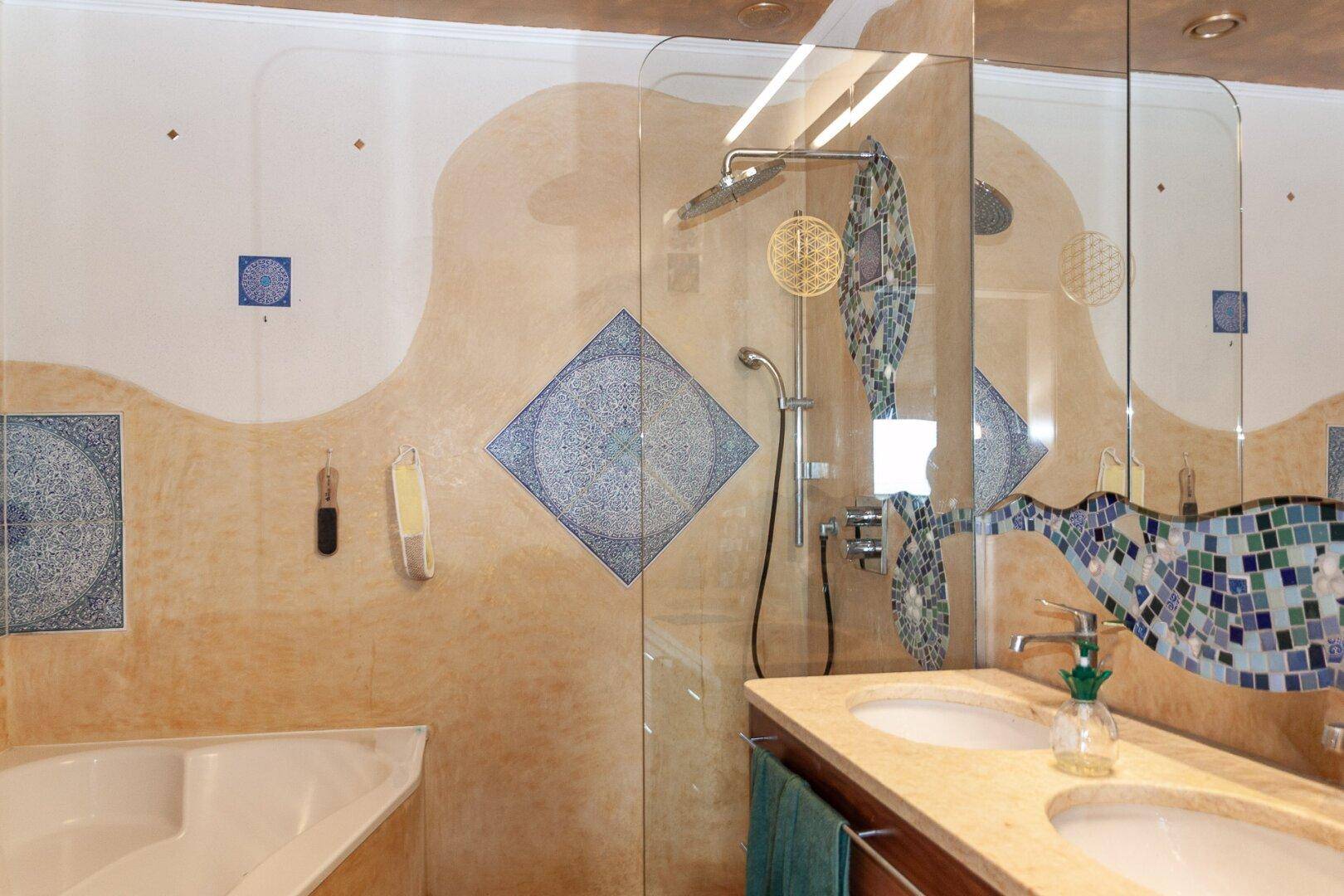 Modernes Badezimmer mit dekorativen Fliesen, Eckbadewanne, Dusche und Doppelwaschbecken.