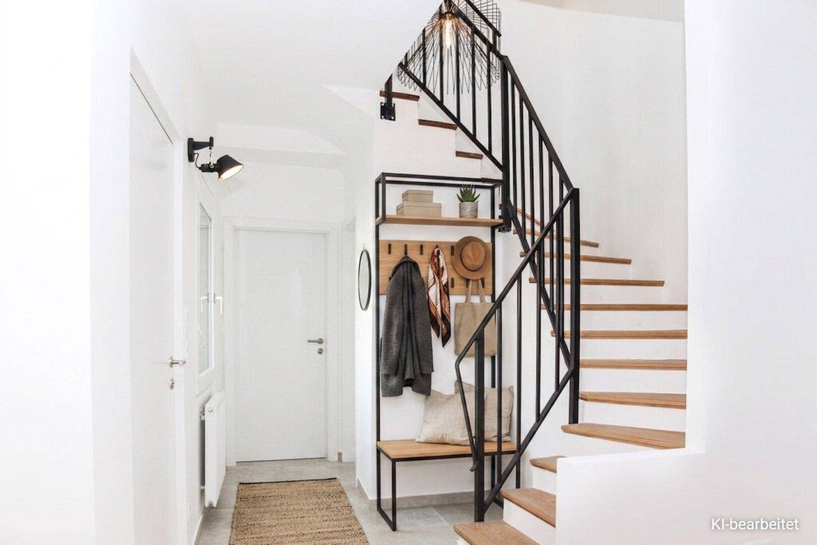 Heller Eingangsbereich mit moderner Garderobe unter der Holztreppe und Metallgeländer.
