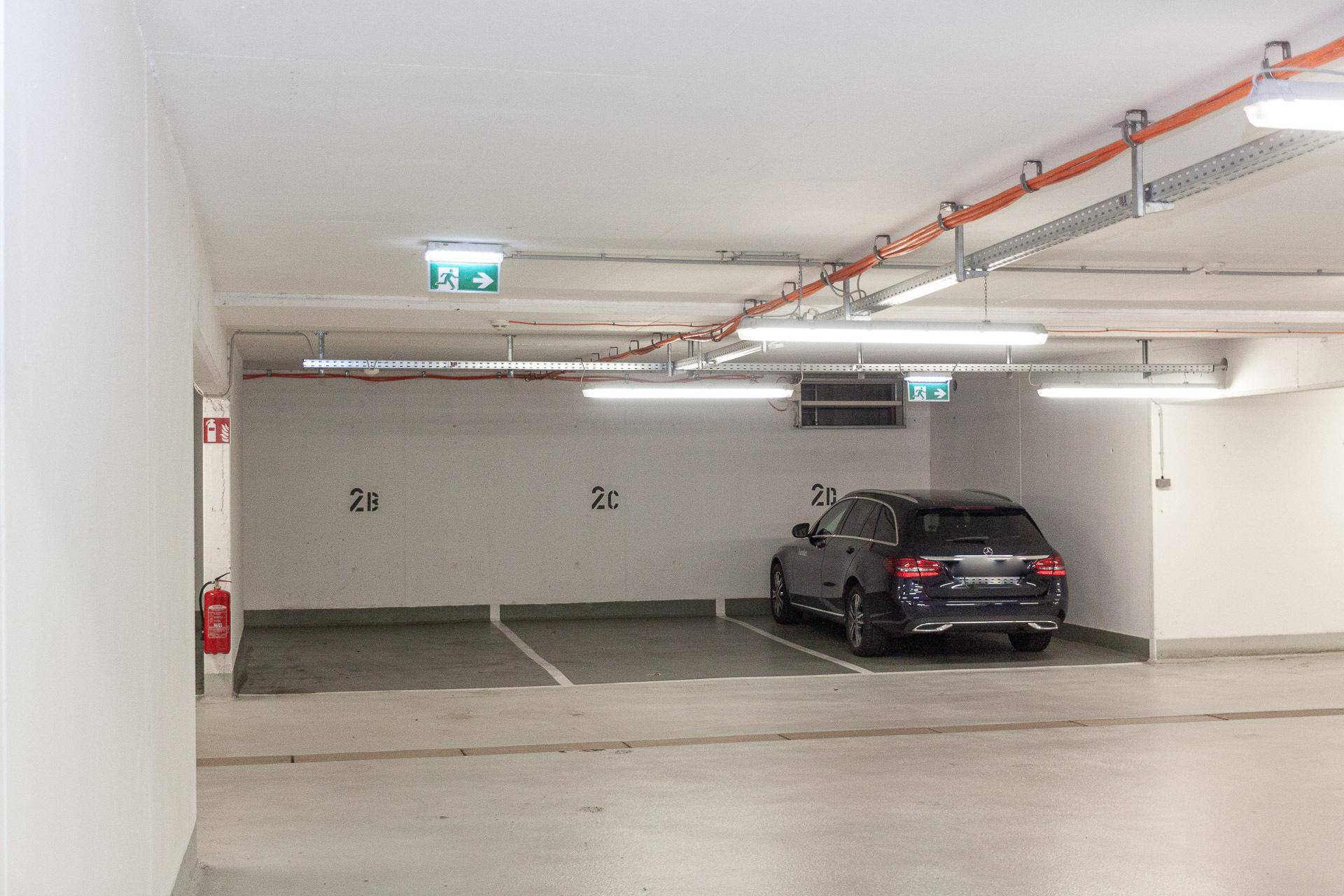 Tiefgarage mit markierten Stellplätzen und einem geparkten Fahrzeug.