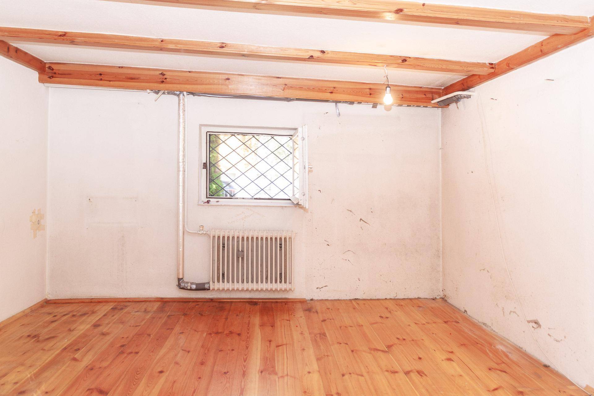 Kellerraum mit Holzbalken an der Decke und Holzfußboden, ideal als Hobbyraum.