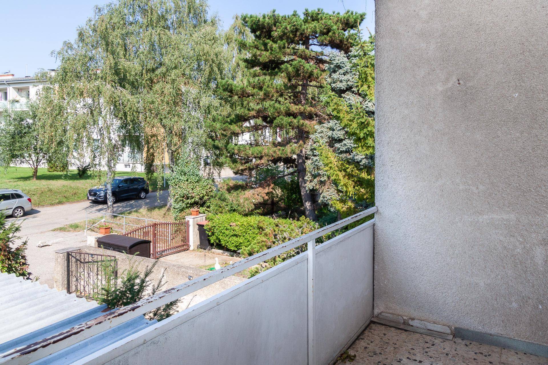 Kleiner Balkon mit Blick auf die grüne Umgebung und die Straße.