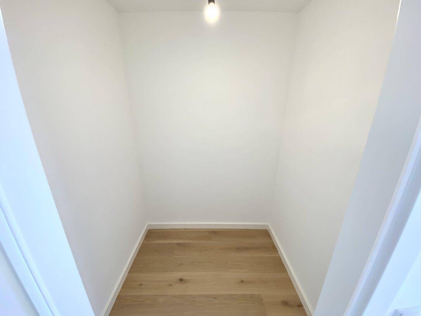Kleiner, leerer Abstellraum mit Holzboden, ideal für zusätzlichen Stauraum.