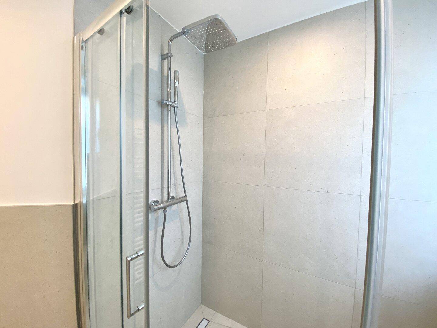 Moderne begehbare Dusche mit Regenduschkopf für ein luxuriöses Duscherlebnis.