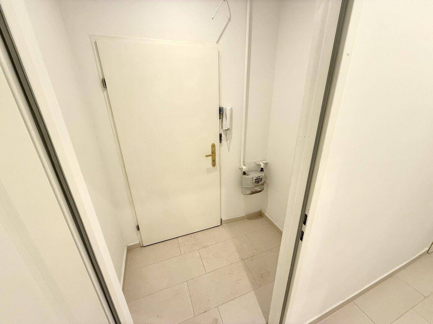 Eingangsbereich mit Fliesenboden und Gegensprechanlage, bietet einen ersten Blick in die Wohnung.