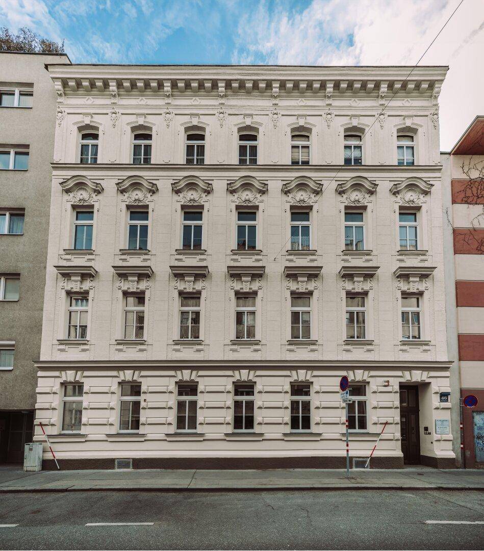 Detailansicht der eleganten historischen Fassade mit reich verzierten Fenstern und Stuckelementen.