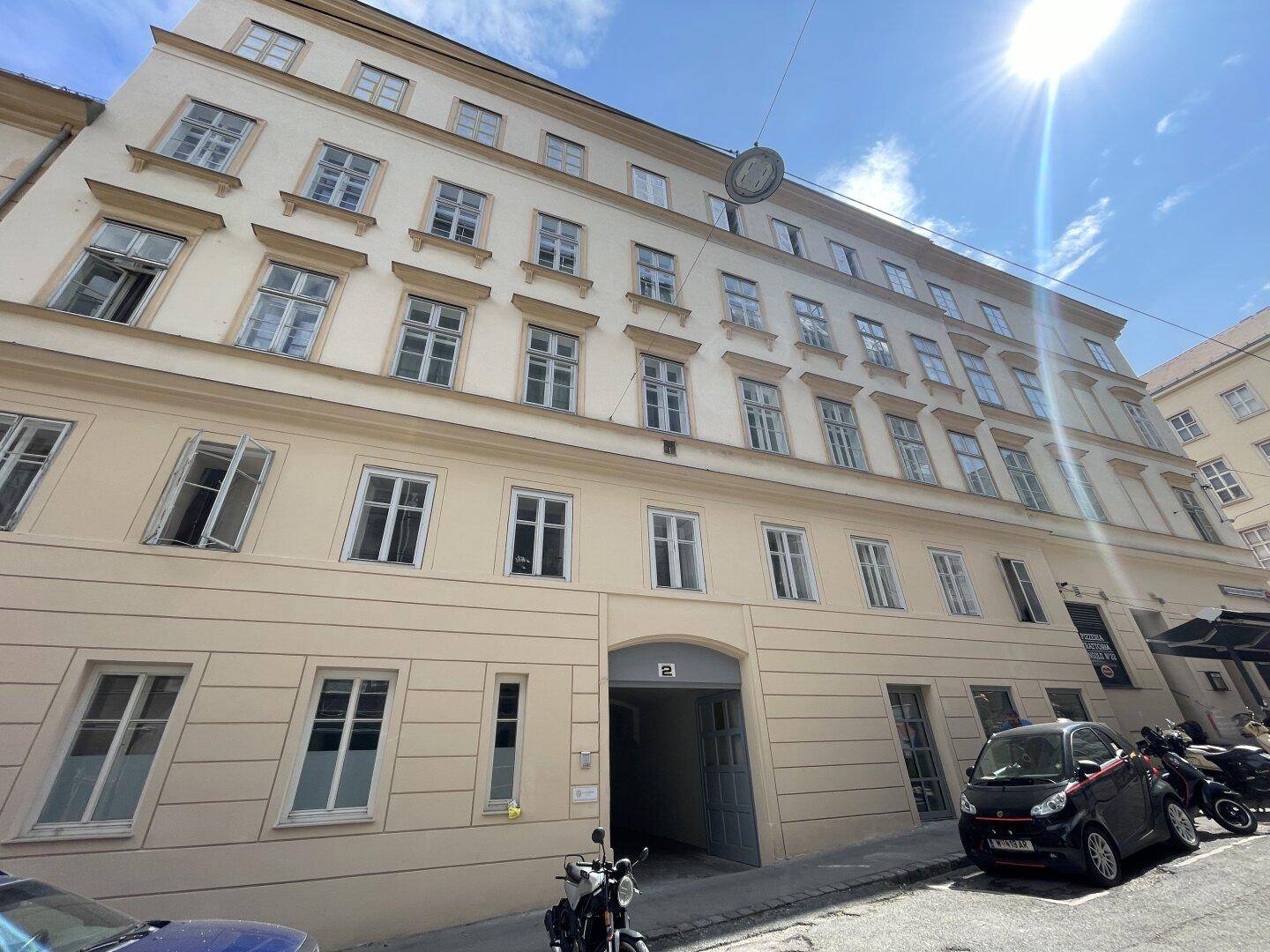 Fassade eines historischen Wohngebäudes mit vielen Fenstern und einem Eingangsbereich.