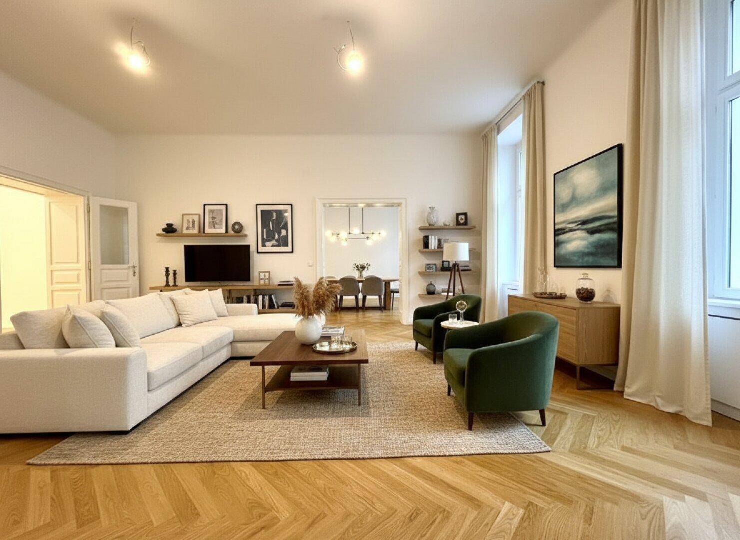 Geräumiges Wohnzimmer mit elegantem Fischgrätparkett, hohen Decken und Blick in den Essbereich.