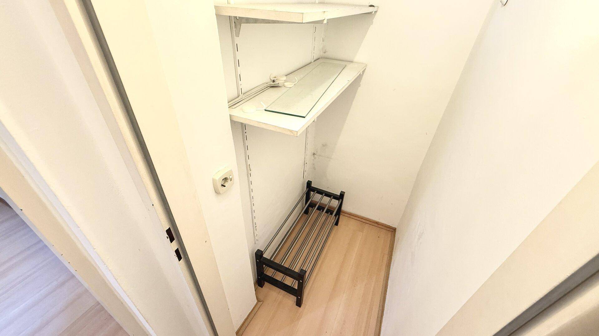 Kleiner Abstellraum mit Regalen und Schuhregal, ideal für zusätzlichen Stauraum.