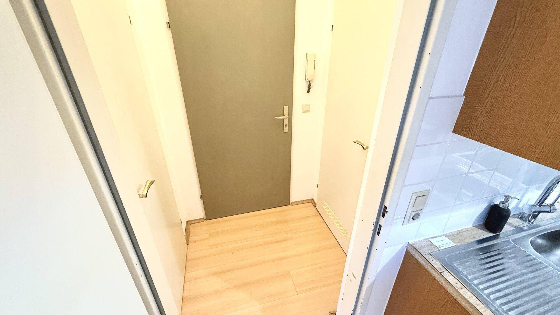 Eingangsbereich mit Gegensprechanlage und Laminatboden, angrenzend an die Küche.