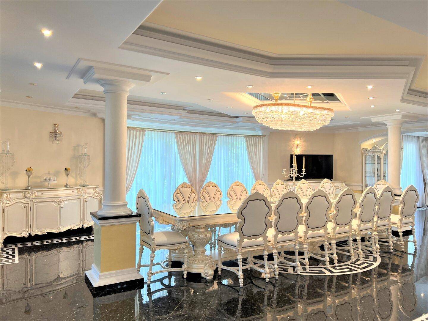 Opulenter Speisesaal mit einem langen Esstisch, passenden Stühlen und einem glänzenden Granitboden.