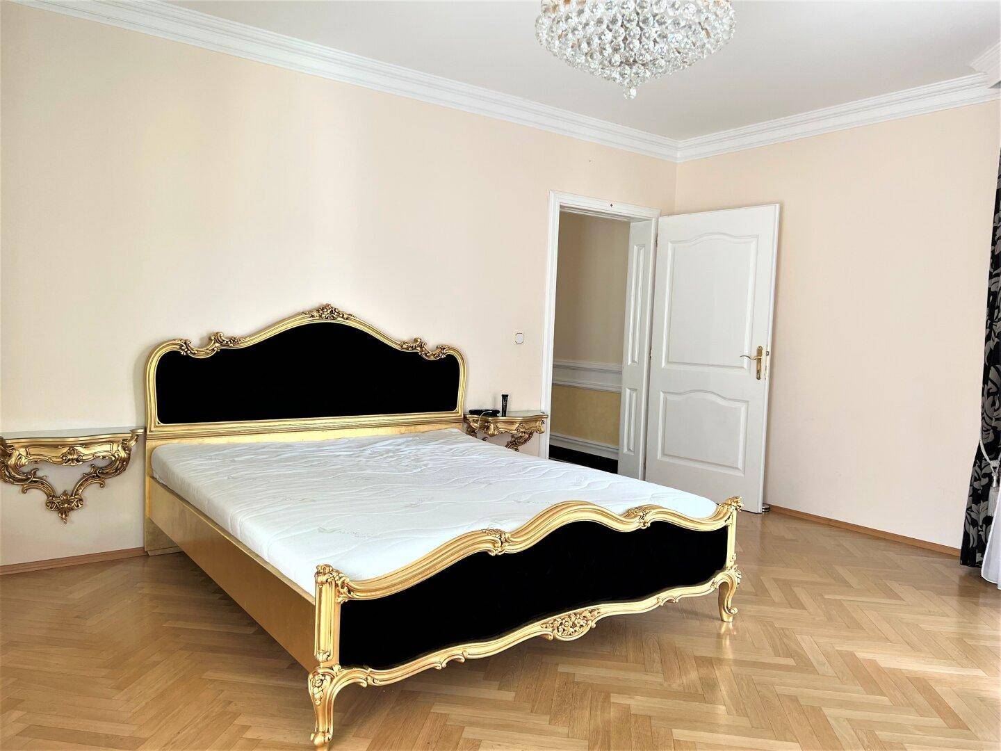 Schlafzimmer mit opulentem Bettrahmen und goldenen Akzenten.