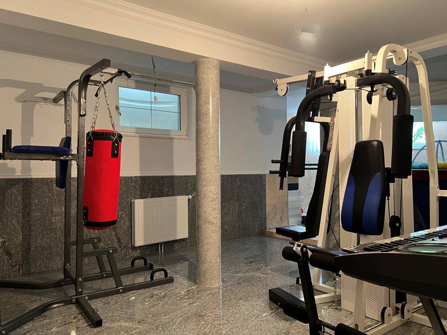 Fitnessraum im Untergeschoss mit verschiedenen Trainingsgeräten.