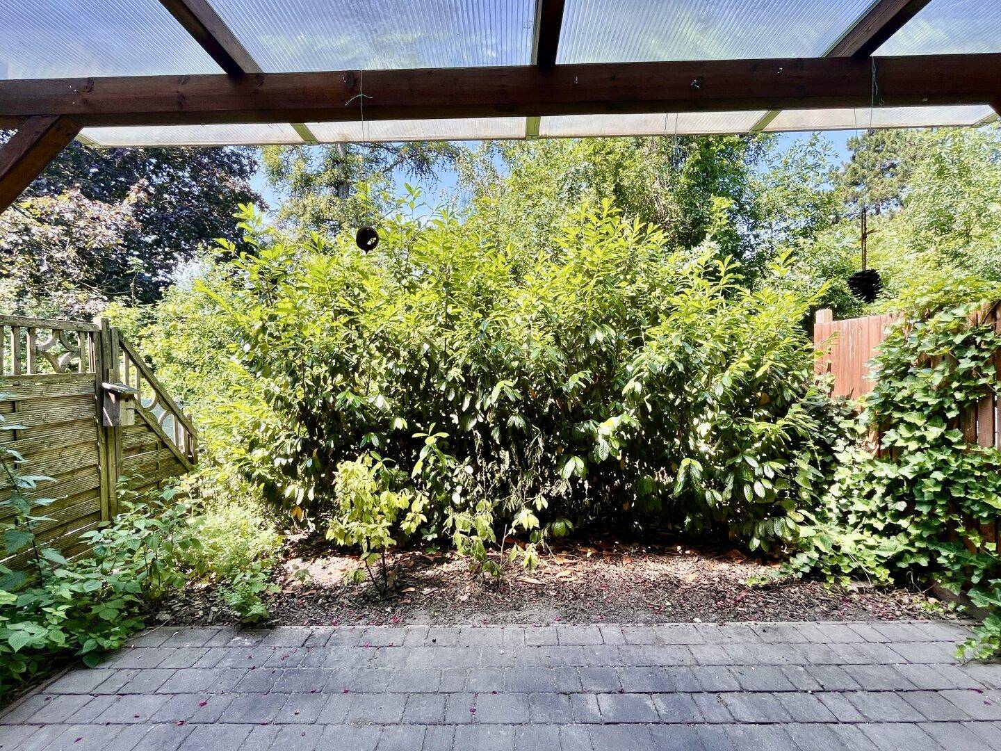 Blick von der Terrasse in den dicht bewachsenen Garten mit viel Privatsphäre und Natur.